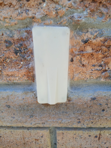 Weep guard attached to brick wall